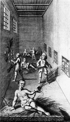 Long, rectangular asylum room, with man in front chained on straw bed throwing water from a pail